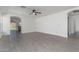 Spacious living room with modern flooring, a ceiling fan, and neutral paint at 22963 W La Pasada Blvd, Buckeye, AZ 85326