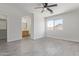 Main bedroom featuring tile flooring, neutral paint, a ceiling fan, and bathroom access at 22963 W La Pasada Blvd, Buckeye, AZ 85326