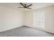 A neutral bedroom with soft carpet, a fan, and window with blinds at 2307 W Nido Ave, Mesa, AZ 85202