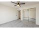 This bedroom features carpet, a ceiling fan, closet, and a door leading outside at 2307 W Nido Ave, Mesa, AZ 85202