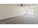 A spacious bedroom is freshly painted with plush gray carpet and a modern ceiling fan at 2307 W Nido Ave, Mesa, AZ 85202