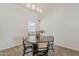 Dining area featuring a modern chandelier and a round wood table with black chairs at 2307 W Nido Ave, Mesa, AZ 85202