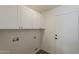Clean laundry room featuring overhead cabinets, hookups, and a utility sink at 2307 W Nido Ave, Mesa, AZ 85202