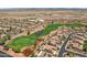 Expansive aerial view of a desert golf community featuring a lush green golf course, water features, and beautiful tile roof homes at 23225 N Hank Raymond Dr, Sun City West, AZ 85375
