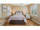 Cozy bedroom with hardwood floors, accent chair, and large windows at 23225 N Hank Raymond Dr, Sun City West, AZ 85375