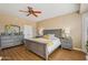 Spacious main bedroom features hardwood floors, a ceiling fan, and neutral decor, offering a comfortable space at 23225 N Hank Raymond Dr, Sun City West, AZ 85375