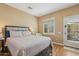 Cozy bedroom featuring a door to the outside and a large window for natural light at 23225 N Hank Raymond Dr, Sun City West, AZ 85375