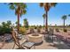 Backyard fire pit with chairs, offering a cozy spot for enjoying evenings with stunning views of the golf course at 23225 N Hank Raymond Dr, Sun City West, AZ 85375