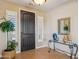 Foyer with dark wood door, sleek glass table and designer mirror and lighting at 23225 N Hank Raymond Dr, Sun City West, AZ 85375
