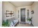 Inviting covered porch with seating, decor, and a stylish front door at 23225 N Hank Raymond Dr, Sun City West, AZ 85375