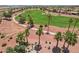 Aerial view of lush golf course with desert landscaping, palm trees, and firepit seating area at 23225 N Hank Raymond Dr, Sun City West, AZ 85375
