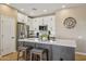 Modern kitchen features white cabinets, stainless steel appliances, and a large island with bar seating at 23225 N Hank Raymond Dr, Sun City West, AZ 85375