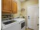 Laundry room with white washer, dryer, and ample cabinet space, making chores efficient and organized at 23225 N Hank Raymond Dr, Sun City West, AZ 85375