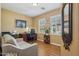 Comfortable home office with hardwood floors, shuttered windows, and ample natural light creates a productive space at 23225 N Hank Raymond Dr, Sun City West, AZ 85375