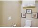 Half-bathroom featuring a toilet, cabinet, artwork, and neutral wall color at 23225 N Hank Raymond Dr, Sun City West, AZ 85375