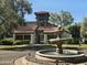 Community clubhouse with a water fountain feature, mature landscaping, and tile roofing at 2333 E Southern Ave # 1049, Tempe, AZ 85282