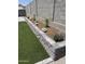 Artificial lawn and a charming flower garden along the backyard wall at 2364 N 212Th Ave, Buckeye, AZ 85396