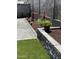 Landscaped backyard with retaining wall, rocks, flowers, and artificial turf at 2364 N 212Th Ave, Buckeye, AZ 85396