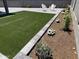 Landscaped backyard features an artificial lawn, gravel, and lovely flowers with seating area at 2364 N 212Th Ave, Buckeye, AZ 85396