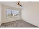 Cozy bedroom with a ceiling fan and view of the outdoors from the window at 2364 N 212Th Ave, Buckeye, AZ 85396