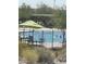 Lovely community pool featuring a secure fence, ample seating, and lush desert landscaping at 2364 N 212Th Ave, Buckeye, AZ 85396