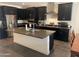 Modern kitchen with stainless steel appliances, dark cabinetry, gray countertop, and a large island at 2364 N 212Th Ave, Buckeye, AZ 85396