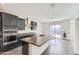 Spacious kitchen boasts stainless appliances, dark cabinets, light gray countertops and a large island at 2364 N 212Th Ave, Buckeye, AZ 85396