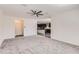 Spacious living room features neutral carpet, a ceiling fan, and open concept to the kitchen at 2364 N 212Th Ave, Buckeye, AZ 85396