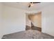 Open living room with neutral carpet, ceiling fan, and view of the staircase at 2364 N 212Th Ave, Buckeye, AZ 85396