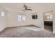 Cozy bedroom features a ceiling fan, plush carpet and large window at 2364 N 212Th Ave, Buckeye, AZ 85396