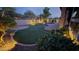 Green outdoor space features ambient lighting, lush greenery, and a water feature for relaxing evenings at 2413 W Kachina Trl, Phoenix, AZ 85041