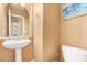 Small powder room featuring a pedestal sink, neutral wall colors, and a lake-themed artwork at 2413 W Kachina Trl, Phoenix, AZ 85041
