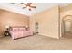 Spacious main bedroom features a ceiling fan, ensuite bathroom, and neutral carpeting at 2413 W Kachina Trl, Phoenix, AZ 85041
