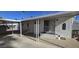 Exterior of a home with a small porch, a carport and mature palm trees at 25 S 102Nd St # 92, Mesa, AZ 85208