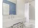 Modern bathroom featuring a sleek sink with chrome fixtures, blue accent wall, and white tiled shower-tub at 2636 S Bahama Dr, Gilbert, AZ 85295