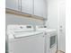 Bright laundry room featuring a modern washer and dryer and ample storage in the upper cabinets at 2893 W Five Mile Peak Rd, San Tan Valley, AZ 85144