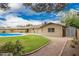 Expansive backyard with a swimming pool, lush lawn, mature trees, and a charming garden at 3010 E Cortez St, Phoenix, AZ 85028