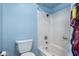 Cozy bathroom featuring a shower-tub combination with a shower curtain, a toilet, and blue walls at 3010 E Cortez St, Phoenix, AZ 85028