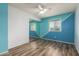 Well-lit bedroom showcasing a blue-and-white accent wall, ceiling fan, and sliding closet doors at 3010 E Cortez St, Phoenix, AZ 85028