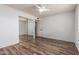 Spacious bedroom with new flooring, a ceiling fan, mirrored closet doors, and an open door at 3010 E Cortez St, Phoenix, AZ 85028