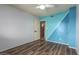 Open bedroom view featuring a ceiling fan, new floors, a light blue accent wall, and an open door to another room at 3010 E Cortez St, Phoenix, AZ 85028