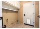Functional laundry room featuring storage cabinets, shelving, and access to the exterior through a white door at 3010 E Cortez St, Phoenix, AZ 85028