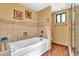 A bright bathroom is equipped with a soaking tub, tiled walls, and a glass door shower at 3027 N Nebraska St, Chandler, AZ 85225
