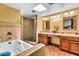 A full bathroom features both a soaking tub, glass shower, double sinks, and traditional lighting fixtures at 3027 N Nebraska St, Chandler, AZ 85225