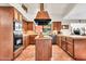 A charming kitchen features wood cabinets, tile flooring, an island cooktop, and modern appliances at 3027 N Nebraska St, Chandler, AZ 85225