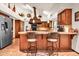 This kitchen offers wood cabinets, tile flooring, granite countertops, and an island with seating at 3027 N Nebraska St, Chandler, AZ 85225