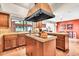 Open kitchen island with granite countertops, cooktop, custom vent hood, cabinets and easy access to the sink at 3027 N Nebraska St, Chandler, AZ 85225