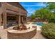 Backyard featuring pool, fire pit with Adirondack chairs, covered patio, and lush vegetation at 3055 N Red Mountain -- # 98, Mesa, AZ 85207