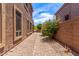 A gravel walkway with a vibrant bush between two buildings under a blue sky at 3055 N Red Mountain -- # 98, Mesa, AZ 85207
