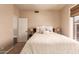 Cozy bedroom featuring a ceiling fan, a side table, a view of the home next door, and a closet at 3055 N Red Mountain -- # 98, Mesa, AZ 85207